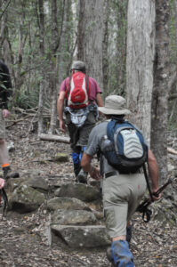 2 men hiking up a hill